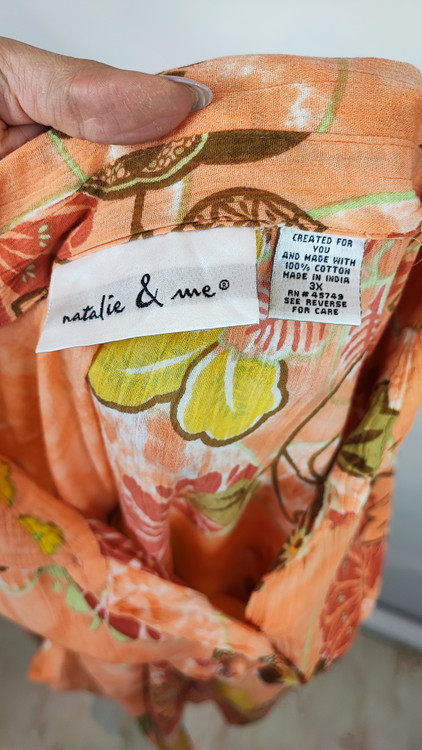 شومیز زنانه طرحدار نارنجی وارداتی با قواره آزاد کد ۱ * تصویر جزئیات: نمای نزدیک از زدگیهای جزئی در بافت پارچه شومیز استوک کد