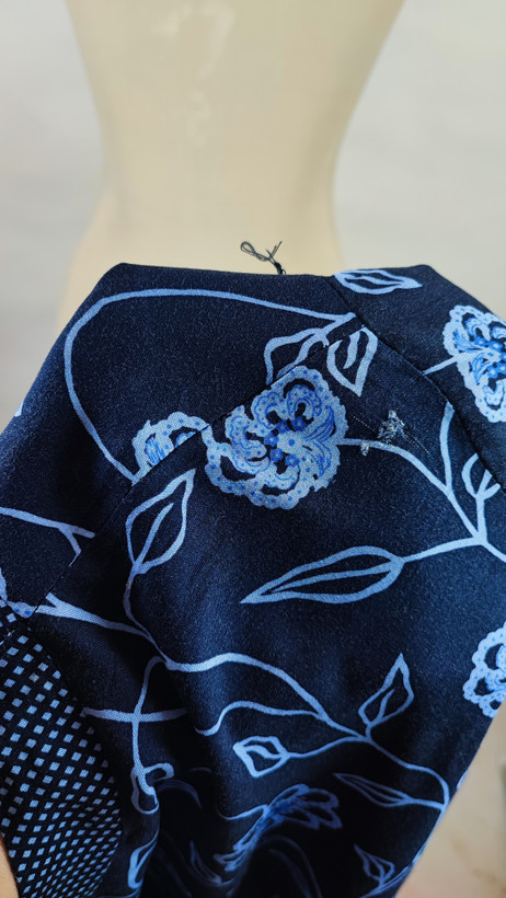 شومیز مجلسی زنانه سرمهای با گلهای آبی وارداتی کد ۱ * تصویر جزئیات: نمای نزدیک از زدگی جزئی پارچه در قسمت سرشانه شومیز استوک