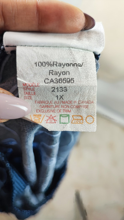 شومیز مجلسی زنانه سرمهای با گلهای آبی وارداتی کد ۱ * تصویر جزئیات: نمای نزدیک از زدگی جزئی پارچه در قسمت سرشانه شومیز استوک