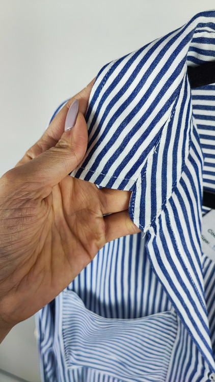 شومیز سفید زنانه با طرحهای انتزاعی مشکی و یقه کراواتی کد ۱۹۷۰ * تصویر جزئیات: نمای نزدیک از دکمه شومیز مجلسی وارداتی جهت بررسی ایراد جزئی