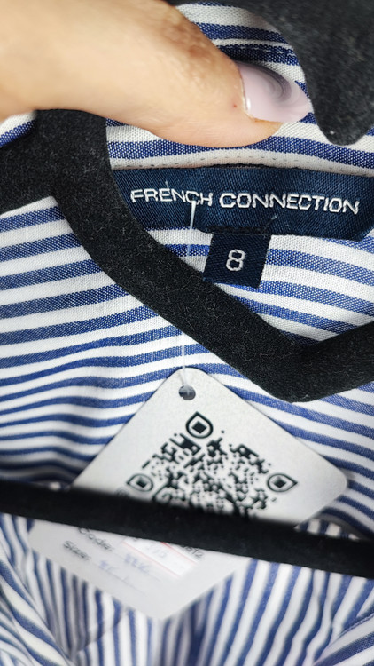 شومیز سفید زنانه با طرحهای انتزاعی مشکی و یقه کراواتی کد ۱۹۷۰ * تصویر جزئیات: نمای نزدیک از دکمه شومیز مجلسی وارداتی جهت بررسی ایراد جزئی