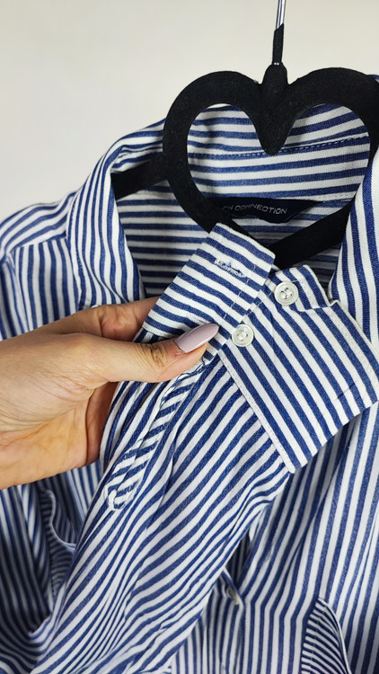 شومیز سفید زنانه با طرحهای انتزاعی مشکی و یقه کراواتی کد ۱۹۷۰ * تصویر جزئیات: نمای نزدیک از دکمه شومیز مجلسی وارداتی جهت بررسی ایراد جزئی