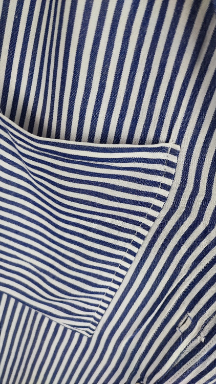 شومیز سفید زنانه با طرحهای انتزاعی مشکی و یقه کراواتی کد ۱۹۷۰ * تصویر جزئیات: نمای نزدیک از دکمه شومیز مجلسی وارداتی جهت بررسی ایراد جزئی