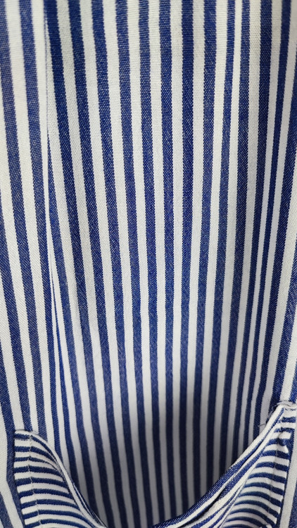 شومیز سفید زنانه با طرحهای انتزاعی مشکی و یقه کراواتی کد ۱۹۷۰ * تصویر جزئیات: نمای نزدیک از دکمه شومیز مجلسی وارداتی جهت بررسی ایراد جزئی