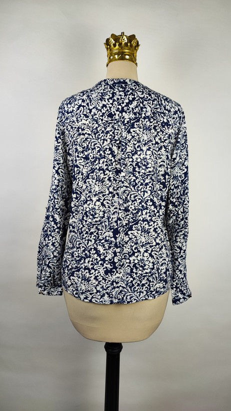 شومیز زنانه طرحدار سرمهای و سفید وارداتی کد ۱ سایز ۴۴ و ۴۶ * نمای تنخور: مدل شومیز یقه هفت دکمهدار استوک اروپایی با شلوار جین * تصویر جزئیات: نمای نزدیک از ایراد زدگی جزئی کنار دوخت بغل شومیز کد