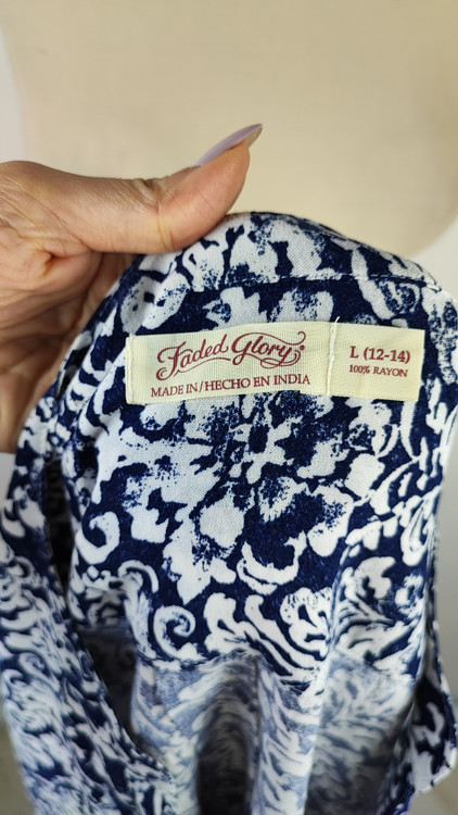 شومیز زنانه طرحدار سرمهای و سفید وارداتی کد ۱ سایز ۴۴ و ۴۶ * نمای تنخور: مدل شومیز یقه هفت دکمهدار استوک اروپایی با شلوار جین * تصویر جزئیات: نمای نزدیک از ایراد زدگی جزئی کنار دوخت بغل شومیز کد