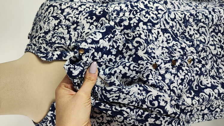 شومیز زنانه طرحدار سرمهای و سفید وارداتی کد ۱ سایز ۴۴ و ۴۶ * نمای تنخور: مدل شومیز یقه هفت دکمهدار استوک اروپایی با شلوار جین * تصویر جزئیات: نمای نزدیک از ایراد زدگی جزئی کنار دوخت بغل شومیز کد