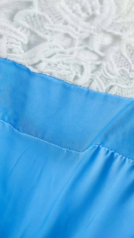 پیراهن مجلسی بلند ترکیبی گیپور سفید و حریر آبی روشن کد ۱۰۲۵ * نمای نزدیک (ایراد): جزئیات ایراد دررفتگی دوخت در لبه گیپور و پشت لباس پیراهن مجلسی کد ۱۰۲۵