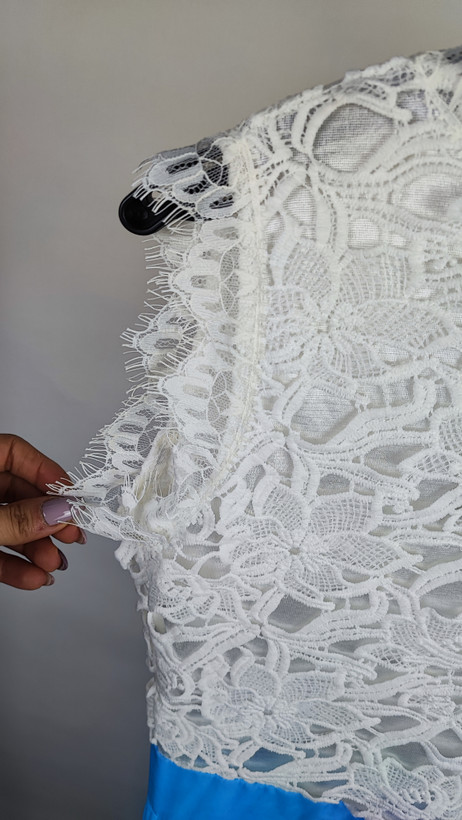 پیراهن مجلسی بلند ترکیبی گیپور سفید و حریر آبی روشن کد ۱۰۲۵ * نمای نزدیک (ایراد): جزئیات ایراد دررفتگی دوخت در لبه گیپور و پشت لباس پیراهن مجلسی کد ۱۰۲۵