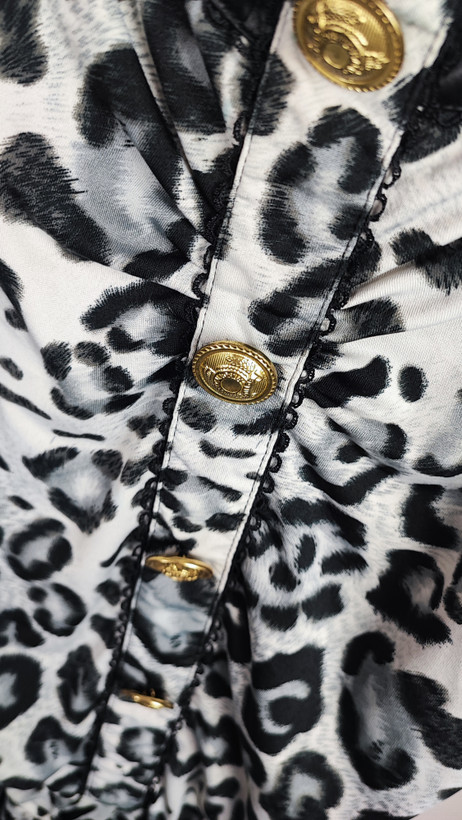 سرهمی کوتاه زنانه طرح پلنگی سفید و مشکی بنددار کد ۹۵۱ مناسب استایل راحتی و خانگی * تصویر جزئیات: نمای نزدیک از دکمههای فلزی طلایی و جیبهای چرمی مشکی رامپر زنانه کد