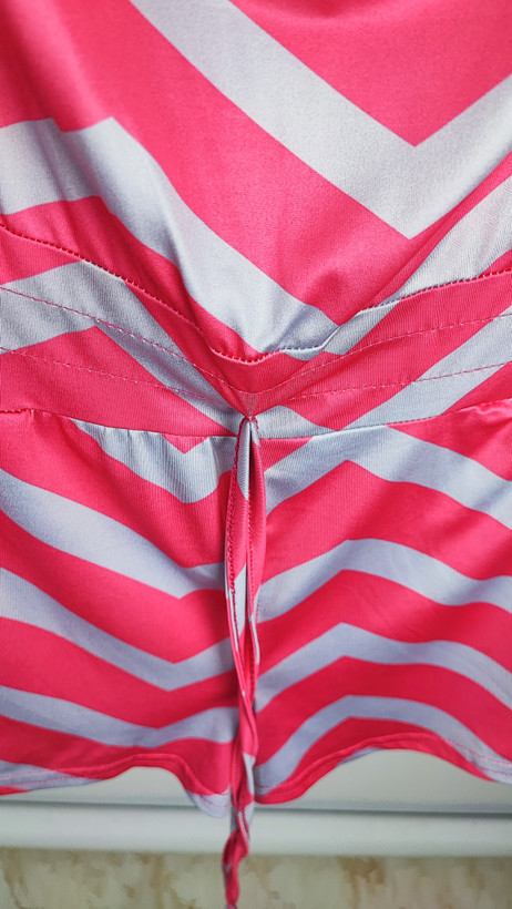 سرهمی کوتاه دکلته زنانه با طرح زیگزاگ صورتی و طوسی کد ۱۰۳۳ مناسب استایل ساحلی و راحتی * تصویر جزئیات: نمای نزدیک از کمر کشی و بند تنظیمی رامپر دکلته زنانه کد ۱۰۳۳ جهت بررسی کیفیت دوخت