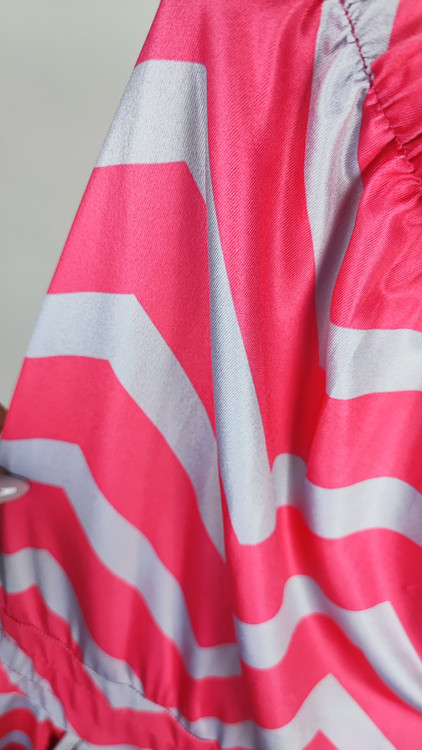 سرهمی کوتاه دکلته زنانه با طرح زیگزاگ صورتی و طوسی کد ۱۰۳۳ مناسب استایل ساحلی و راحتی * تصویر جزئیات: نمای نزدیک از کمر کشی و بند تنظیمی رامپر دکلته زنانه کد ۱۰۳۳ جهت بررسی کیفیت دوخت