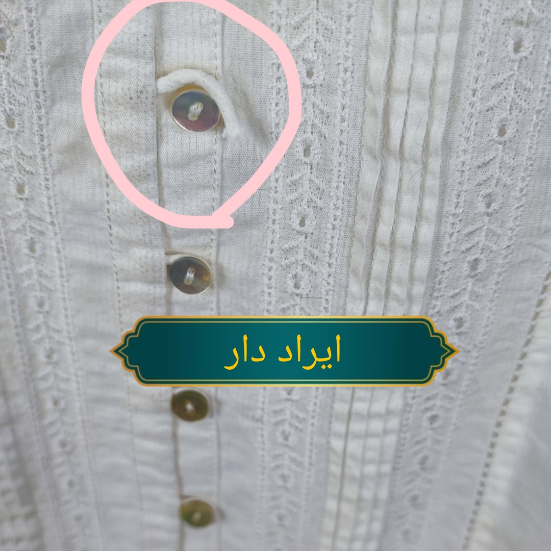 نمای نزدیک از دکمههای شومیز خامه دوزی سفید ماسیمو دوتی زنانه که ایراد جزئی در دوخت جادکمه را نشان میدهد