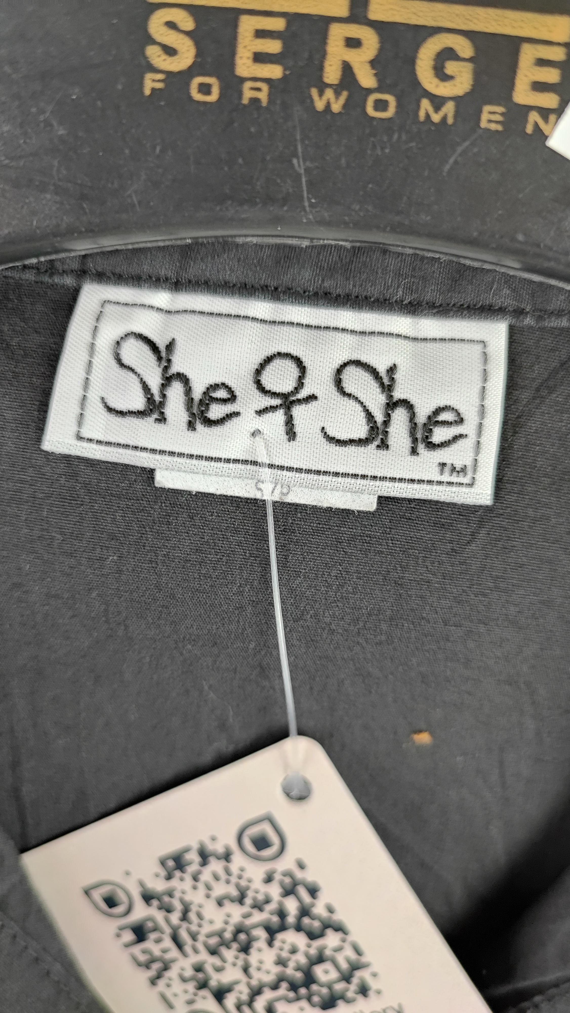 تاپ زنانه مشکی استوک برند She & She، سایز ۳۶.۳۸، با طراحی یقه دار و لوگوی گلدوزی شده، مناسب استایلهای روزمره و کژوال