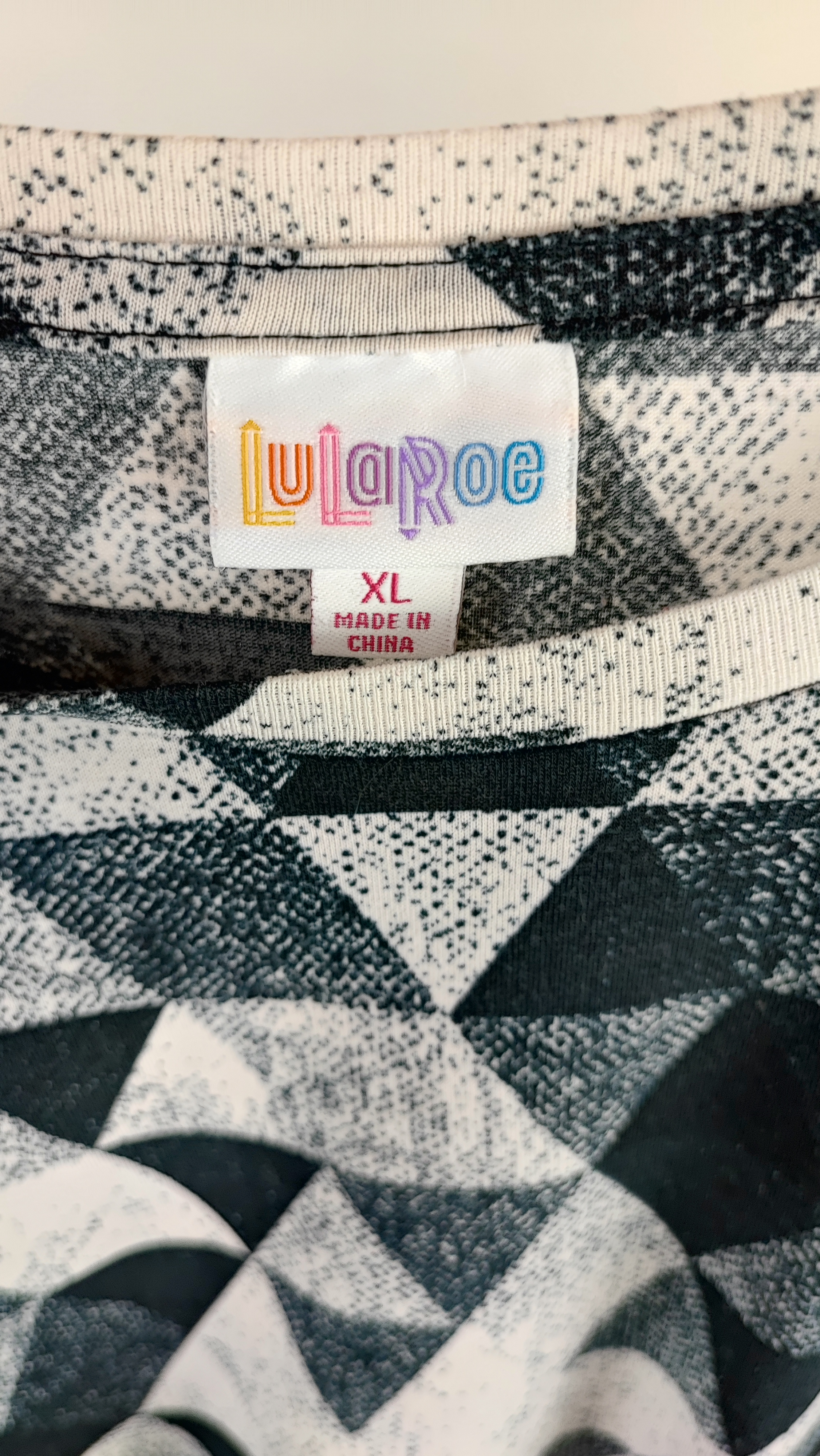 تیشرت زنانه سایز بزرگ برند لولاروئه (LuLaRoe) با طرح هندسی مشکی و سفید، یقه گرد، مناسب استایل کژوال